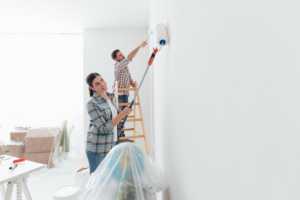woman and man painting a wall in a home