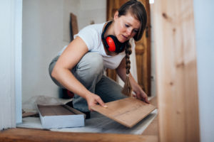 Woman installing laminate flooring